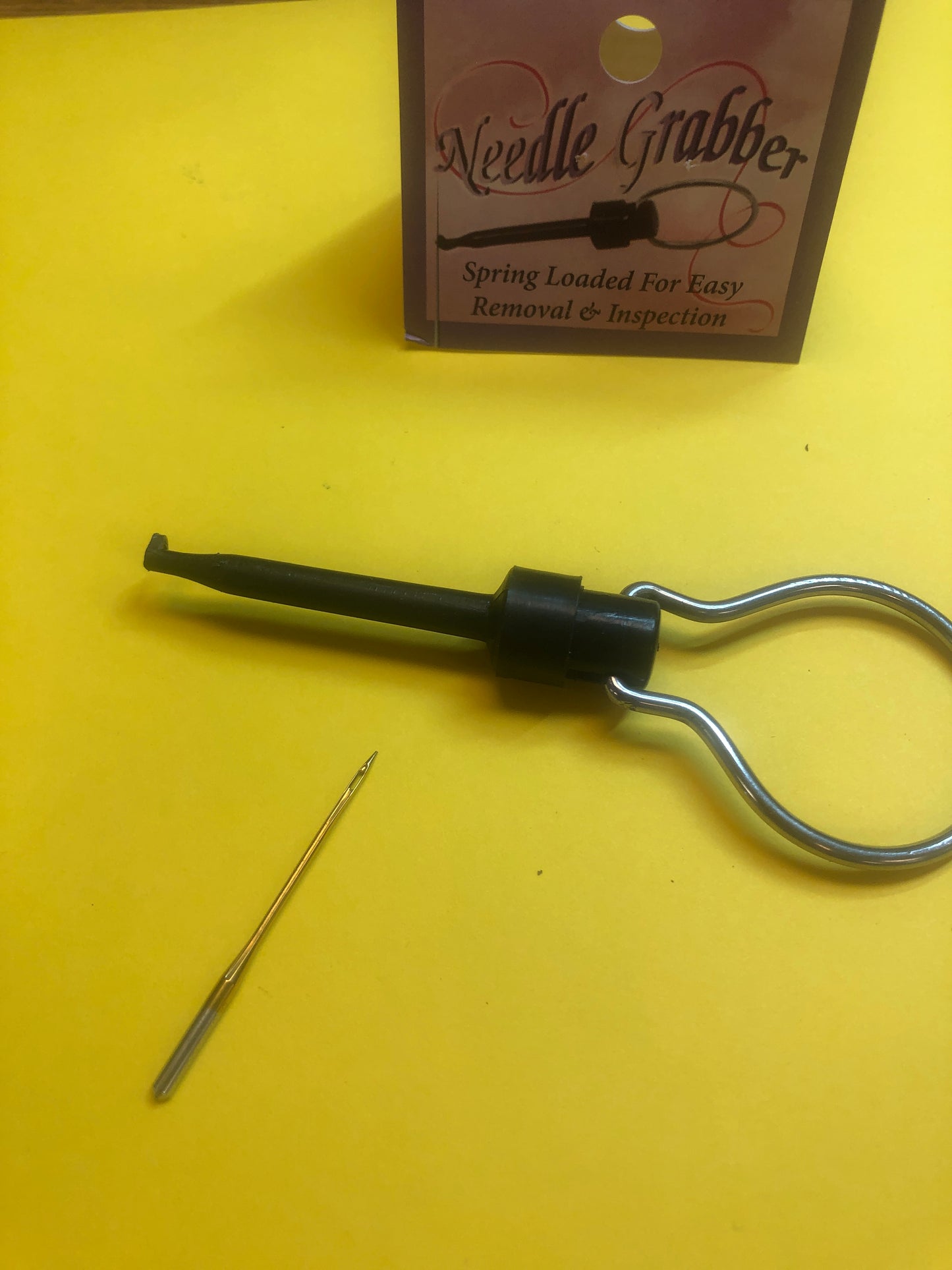 Needle Grabber with handle. Spring loaded hook to hold sewing machine needle to insert in machine